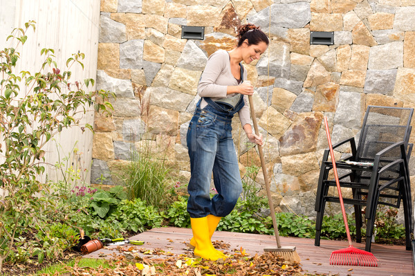 Young woman sweeping leaves veranda backyard happy Stock photo © CandyboxPhoto