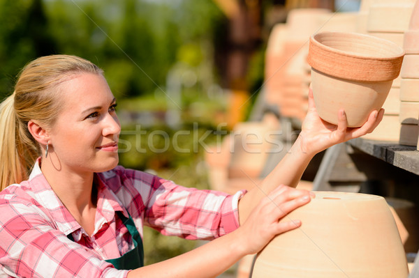 Stock photo: Garden center woman putting clay pots shelf