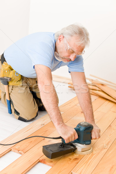 Stock photo: Home improvement - handyman sanding wooden floor 