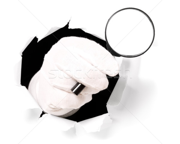 Man with gloves is holding magnifying glass in his finger through a hole Stock photo © carenas1