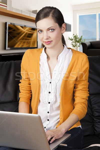 Ragazza divano laptop sorriso guardare lenti Foto d'archivio © carlodapino