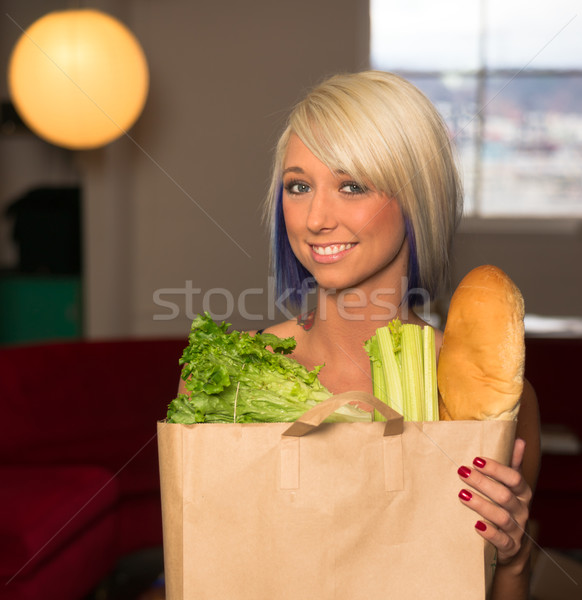 Attractive Female Homemaker Sets Grocery Bag on Counter Stock photo © cboswell