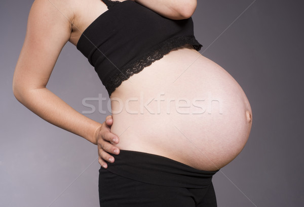 Pregnant Woman Torso Standing Bending Black Clothes Gray Backgro Stock photo © cboswell