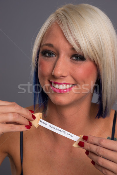 Stock photo: Pretty Blonde Woman Eats Fortune Cookie Showing Message