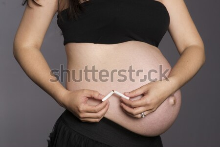 Pregnant Woman Belly Holding Breaking Cigarette in Half No Smoki Stock photo © cboswell