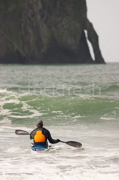Man Paddles into Ocean Surf Riding Sea Kayak Boat Sport Stock photo © cboswell