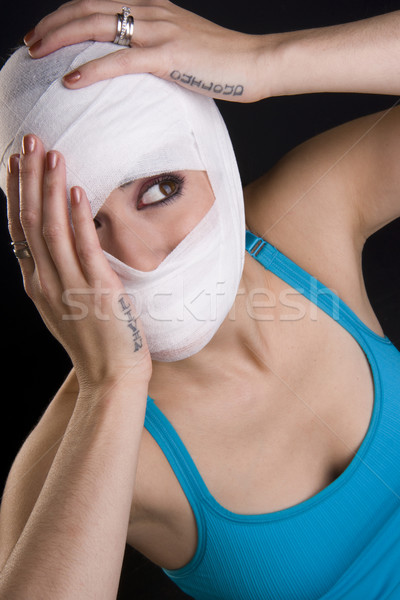 Female Holds Face First Aid Gauze Wrapped Head Injury Pain Stock photo © cboswell