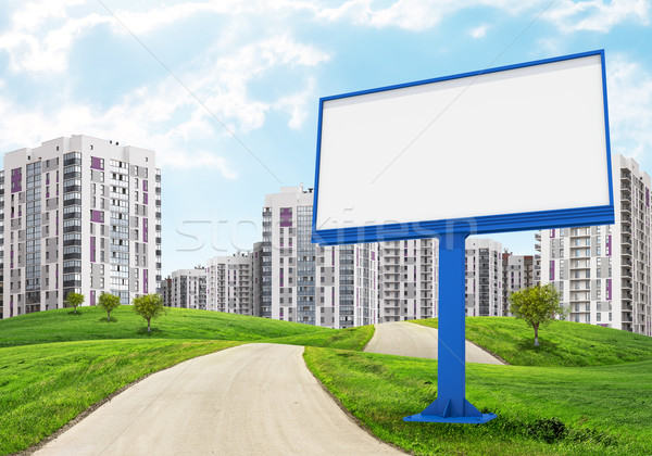 Blank billboard by road running through green hills towards city Stock photo © cherezoff