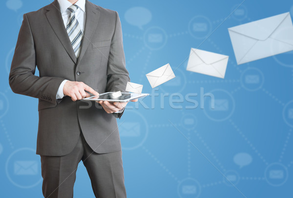 Man in suit holding tablet pc. Mailing concept Stock photo © cherezoff
