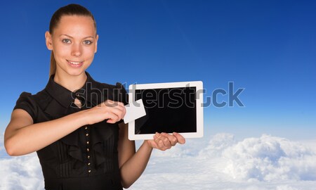 Beautiful businesswoman holding tablet PC. Blue sky, clowds and jet airliner as backdrop Stock photo © cherezoff