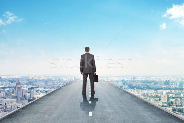 Businessman on road with city Stock photo © cherezoff