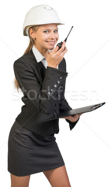 Businesswoman wearing hard hat holding clipboard and walkie talkie Stock photo © cherezoff