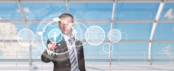 Businessman pressing on holographic screen Stock photo © cherezoff