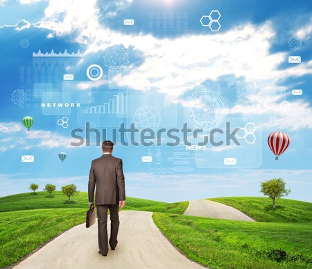 Businessman walks on road. Rear view. Buildings, grass field and sky with virtual elements Stock photo © cherezoff