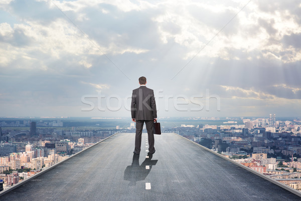 Businessman on road and city, rear view Stock photo © cherezoff