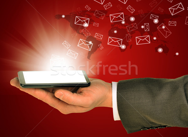 Business man holding a mobile phone within left hand Stock photo © cherezoff