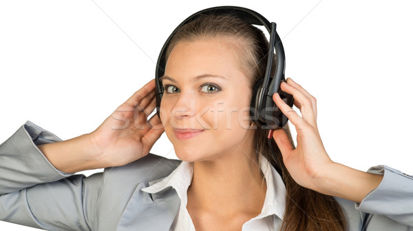 Businesswoman in headset with her hands on speakers Stock photo © cherezoff
