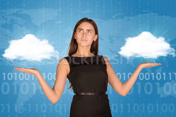 Businesswoman holding two white clouds, as if chosing Stock photo © cherezoff