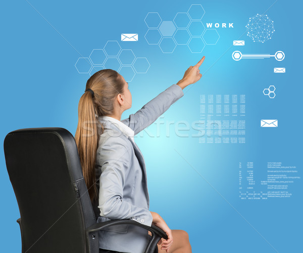 Businesswoman pressing virtual interface Stock photo © cherezoff