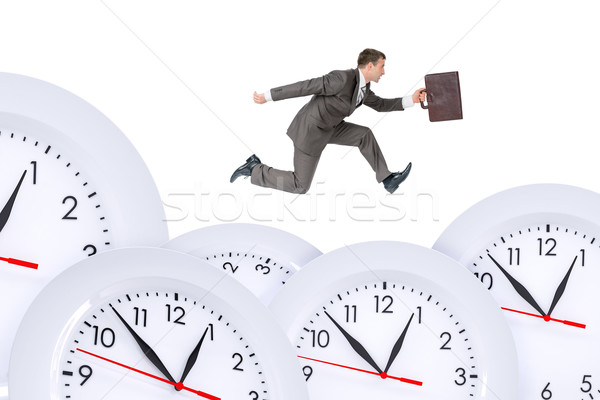 Stock photo: Businessman running with set of clocks