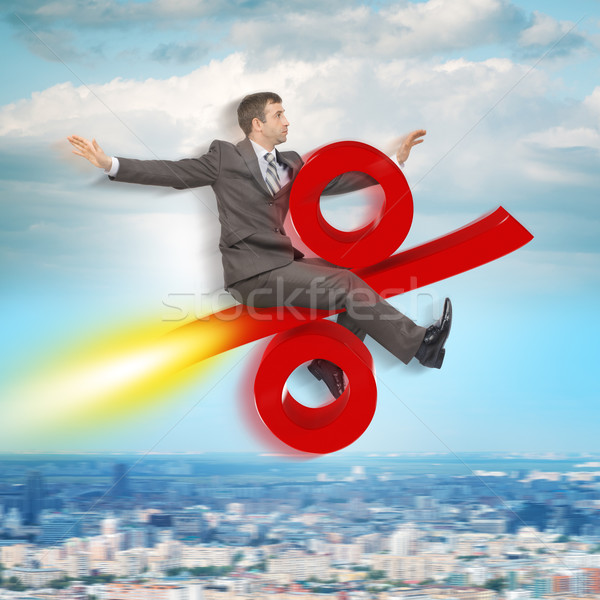 Businessman flying on percent sign Stock photo © cherezoff