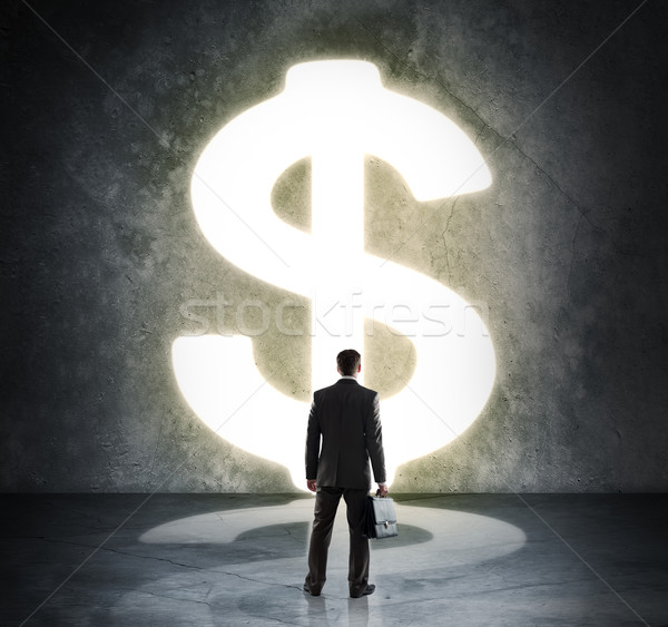 Businessman standing in light of dollar sign Stock photo © cherezoff