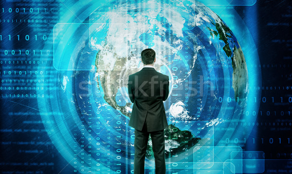 Businessman in front of holographic screen Stock photo © cherezoff