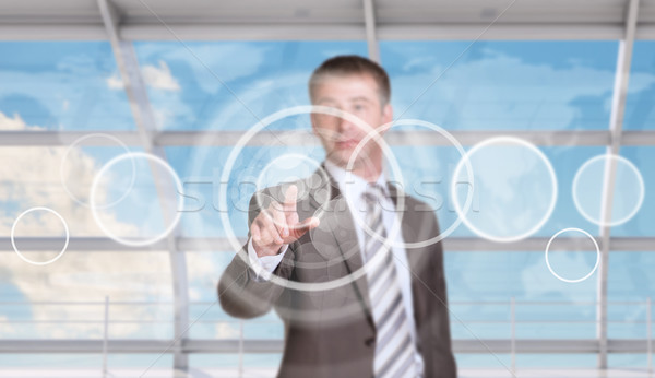 Businessman pressing on holographic screen Stock photo © cherezoff