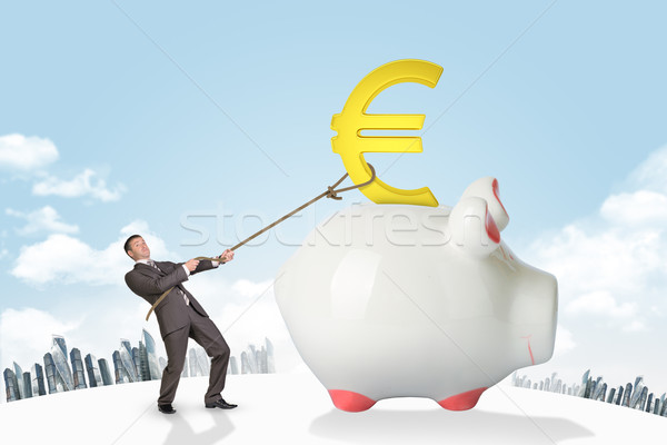 Businessman holding euro sign with rope and city Stock photo © cherezoff