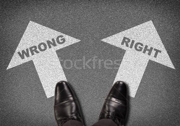 Shoes standing on asphalt road with two arrows. Labels wrong and right Stock photo © cherezoff