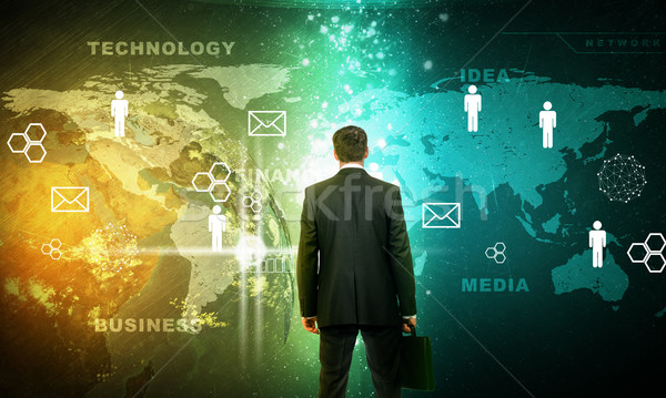 Businessman in front of holographic screen Stock photo © cherezoff