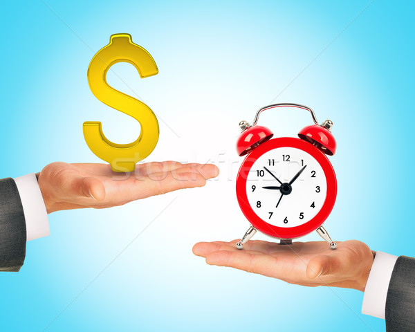 Hand with dollar sign and alarm clock on another  Stock photo © cherezoff