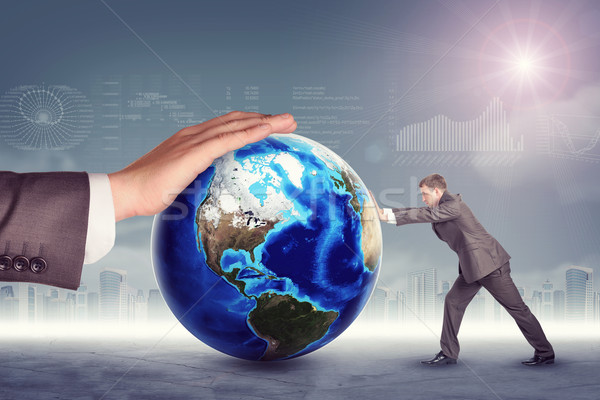 Businessman pushing planet with mans hand Stock photo © cherezoff