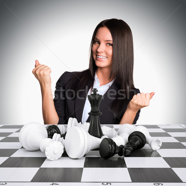 Joyful businesswoman wins chess and raised his hands up Stock photo © cherezoff