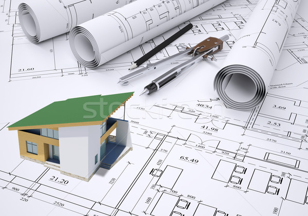 Small model house with green roof near scrolls of architectural drawings and tools Stock photo © cherezoff