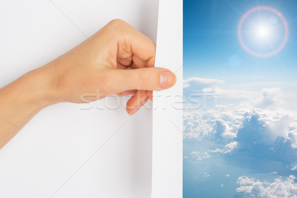 Hand turning the page revealing blue skies Stock photo © cherezoff