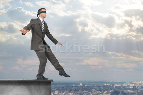 Stock photo: Businessman stepping from edge of building roof