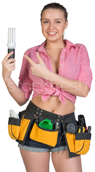 Woman in tool belt holding energy-saving lamp Stock photo © cherezoff