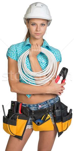 Pretty electrician in helmet, shorts, shirt, tool belt with tools holding an electric cable Stock photo © cherezoff