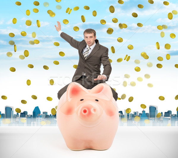 Businessman sitting on piggy bank with money rain Stock photo © cherezoff