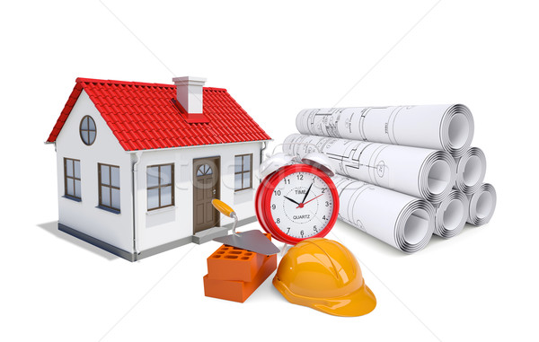 Stock photo: Small model house with red roof near scrolls of architectural drawings and alarm clock