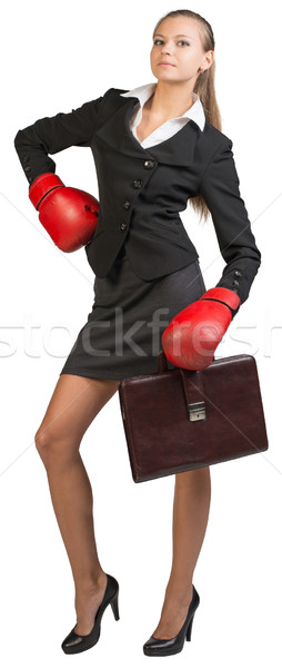 Businesswoman wearing boxing gloves standing akimbo Stock photo © cherezoff