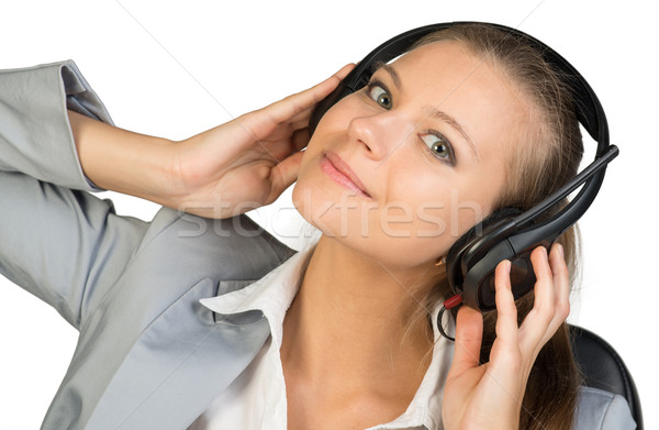 Businesswoman in headset with her hands on speakers Stock photo © cherezoff