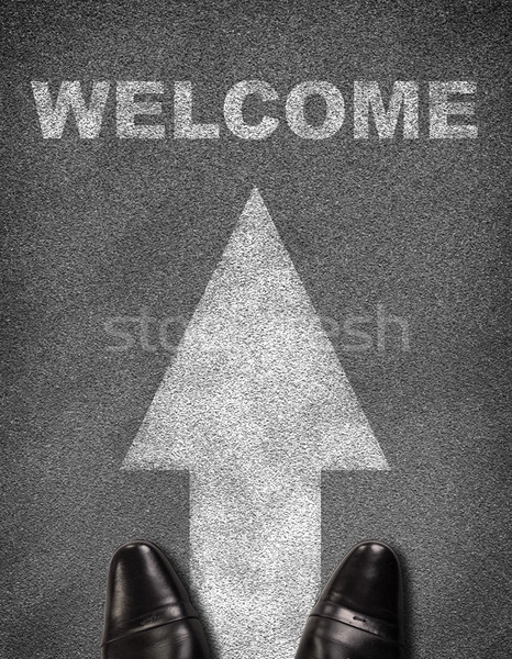 Top view of shoes standing on asphalt road with arrow and word welcome Stock photo © cherezoff
