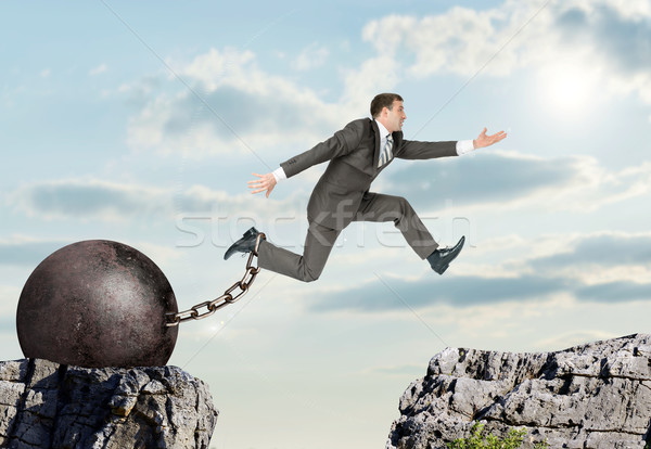 Image of young businessman jumping over gap Stock photo © cherezoff