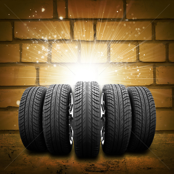 Car wheels. Background is brick wall, concrete floor and light at center Stock photo © cherezoff