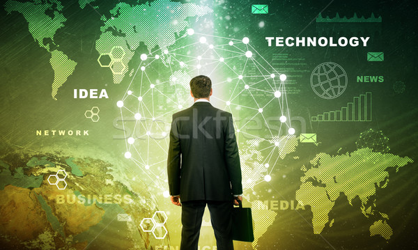 Businessman in front of holographic screen Stock photo © cherezoff
