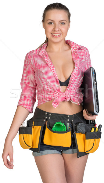 Woman in tool belt, holding laptop under her armpit Stock photo © cherezoff