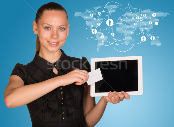 Beautiful businesswoman holding tablet PC. Network with people icons and world map as backdrop Stock photo © cherezoff