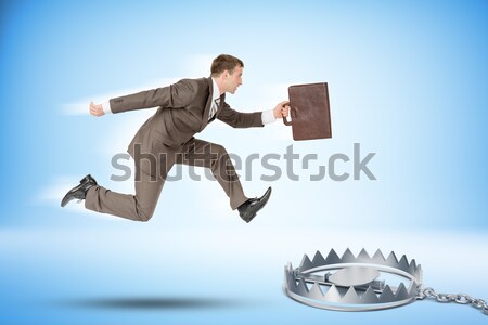 Businessman running forward with piggy bank Stock photo © cherezoff